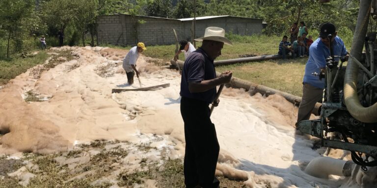 local residents help to clear away debris as the well is being drilled