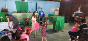(l) carly missionary, (r) child receiving backpack for school